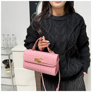 Borsa a mano in pelle intrecciata rosa con chiusura a scatto dorata indossata da modella