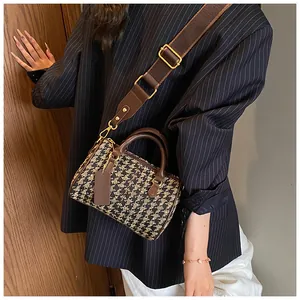 Detail of vintage houndstooth canvas boston bag with brown leather trim and wide strap