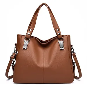 Sac cabas marron en cuir grainé avec poignées et bandoulière réglable sur fond blanc