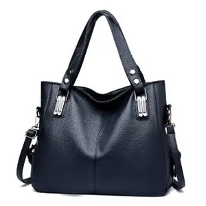 Sac cabas en cuir bleu foncé avec détails argentés et bandoulière sur fond blanc