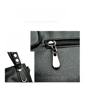 Detail of silver zipper and adjustable buckle on black lychee grain leather tote bag
