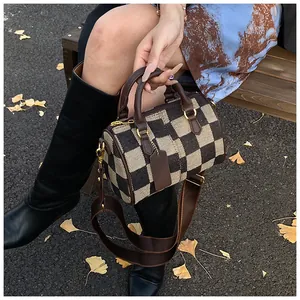 Classic checkered canvas Boston bag with brown leather trim shown in an autumn setting
