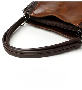 Detail of the thick brown leather shoulder strap and smooth texture on vintage tote bag