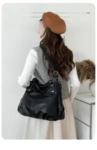 Detail of lychee textured leather tote bag with silver buckle and adjustable strap