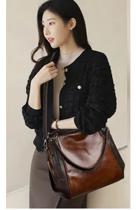 Detail of vintage soft leather tote bag with caramel brown contrast and zip accents