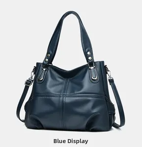 Close-up of navy blue lychee grain leather tote bag with silver hardware and cross stitching