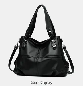 Close-up of black lychee-textured leather tote bag with silver hardware and cross stitching