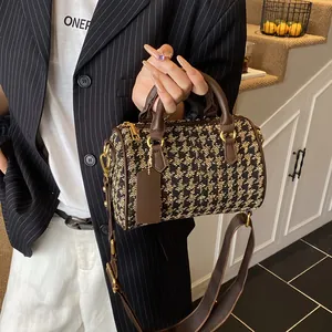 Classic houndstooth canvas Boston bag with brown leather handles and golden hardware