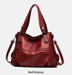 Detail of red litchi texture leather tote with reinforced handles and metal D-ring hardware