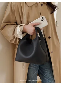 Detalle del bolso de mano en cuero granulado negro con un diseño minimalista elegante