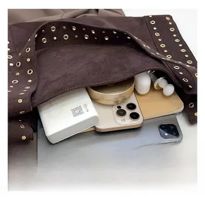 Intérieur spacieux du sac cabas en daim marron foncé avec rivets et accessoires