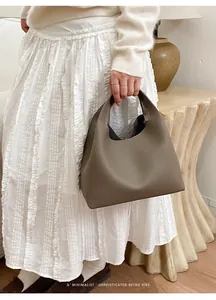 Detalle de bolso tipo cubo en cuero granulado gris elefante con estilo retro minimalista