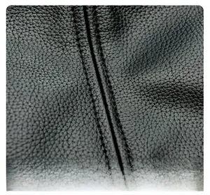 Macro view of precise double-row stitching on black lychee-textured leather bag