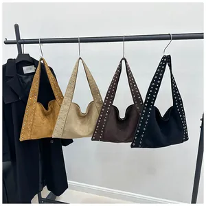 Détail de quatre sacs à bandoulière en daim colorés avec rivets métalliques décoratifs