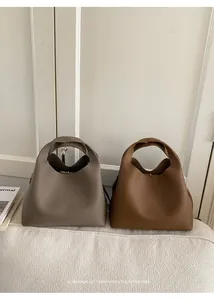 Detalle de la textura de cuero granulado en bolsos de color topo y tostado con cierre magnético
