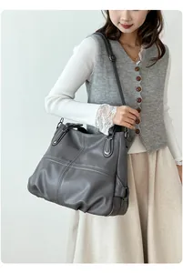 Close-up of the cross-stitch sewing and litchi texture on the dark grey tote bag