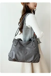 Detail view of large dark grey leather tote bag with lychee texture and shoulder straps