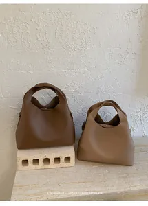 Vista detallada de bolsos de hombro grandes en cuero granulado color café y caqui