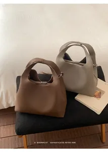 Detalle de bolsos cubo en cuero granulado con herrajes plateados y asas integradas