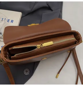 Close-up of brown PU leather crossbody bag interior with gold zipper and magnetic buckle