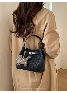 Detalle del bolso de hombro retro negro con textura litchi y cierre de giro plateado