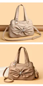 Detail of khaki leather handbag featuring a large 3D bow and sparkling rhinestone buckle
