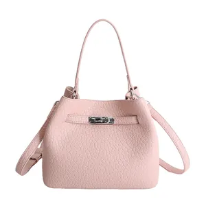 Bolso bucket rosa claro en cuero granulado con cierre de giro plateado y correa doble
