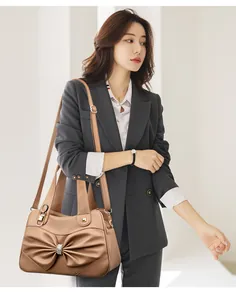 Detail of light khaki leather handbag featuring a large bow and sparkling crystal buckle
