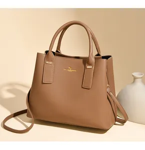 Detailed macro view of the brown pebble leather texture and gold MK KANGAROO logo on bag