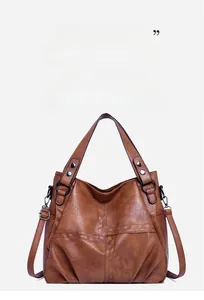 Detail of vintage brown tote bag showing pebble leather texture and metal buckles