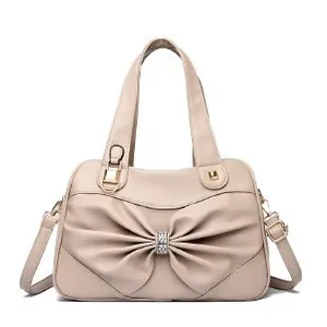 Elegant beige tote bag with a large rhinestone bow and adjustable shoulder strap