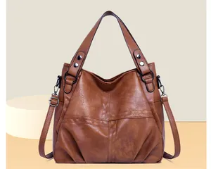 Macro view of vintage brown leather hobo bag with pleated texture and gunmetal hardware
