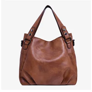 Detailed close-up of the vintage brown tote bag with textured faux leather and rivets