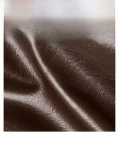 Macro shot of dark brown pebbled faux leather material showing soft texture and sheen