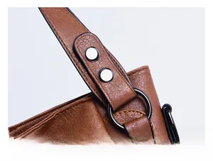 Detail shot of sturdy silver rivets and metal ring on brown leather tote handbag straps