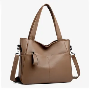 Dettaglio borsa tote in pelle marrone con trama litchi e tasca con cerniera argento