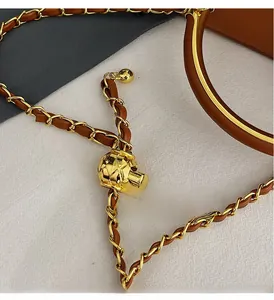 Close-up of golden adjustable metal ball buckle on leather interwoven chain strap