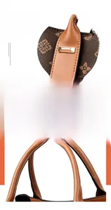 Détail de la poignée en cuir renforcé avec boucles en métal sur le sac monogramme