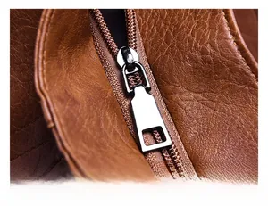 Macro view of silver metal zipper and brown textured leather on minimalist handbag
