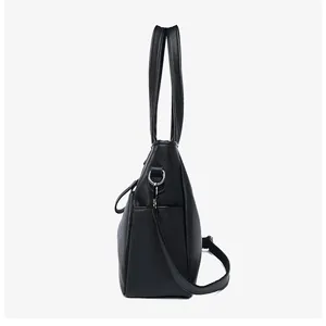 Vista laterale di una borsa shopper nera in pelle martellata con dettagli argentati
