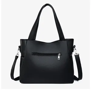 Dettaglio borsa tote nera in ecopelle grana litchi con zip in metallo e tracolla