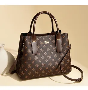 Gros plan sur un sac cabas marron à monogramme avec logo doré et texture cuir grainé