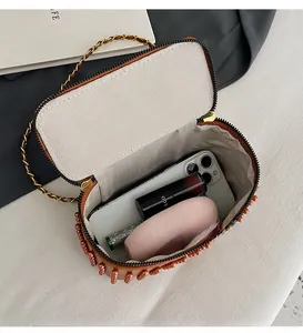 Detailed interior of a brown box bag with orange beading and ample storage space
