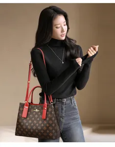 Détails des poignées en cuir rouge et du sac cabas monogramme sur un mannequin