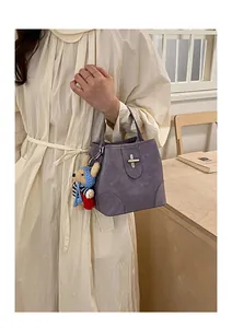 Detail of vintage retro bucket bag in mauve faux leather with cute bear pendant charm