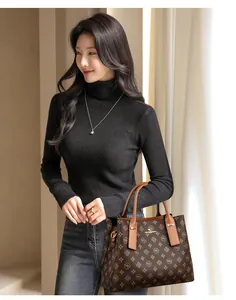 Détail d'un sac cabas à monogramme marron avec poignées en cuir sur une tenue chic