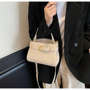 Détail du sac à main en cuir grainé beige avec boucle dorée et bandoulière réglable