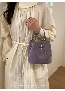 Detailed view of purple suede bucket bag with silver metal swivel lock clasp closure