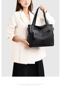 Dettaglio ravvicinato della borsa tote in pelle martellata nera con zip frontale