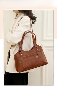 Sac fourre-tout en cuir marron avec poche zippée à l'avant et bandoulière réglable